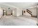 Open basement with neutral carpeting and access to staircase at 10208 E Jewell Ave # 18, Aurora, CO 80247
