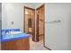 Bathroom features wood vanity with a blue countertop and a tiled bath in the background at 10208 E Jewell Ave # 18, Aurora, CO 80247