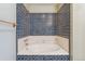 The bathtub has blue tiling, a white base, and is equipped with shower fixtures at 10208 E Jewell Ave # 18, Aurora, CO 80247