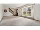 Inviting living room with plush carpeting, a large window, and a dark wood staircase at 10208 E Jewell Ave # 18, Aurora, CO 80247