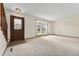 Inviting living room with plush carpeting, a large window, and a dark wood entry door at 10208 E Jewell Ave # 18, Aurora, CO 80247