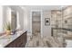 Elegant bathroom featuring a double vanity, a glass-enclosed shower, and a walk-in closet at 4200 W 17Th Ave # 211, Denver, CO 80204