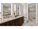 Modern bathroom with dual sinks, granite countertop, and a view into the walk-in closet at 4200 W 17Th Ave # 211, Denver, CO 80204
