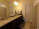 Bright bathroom featuring double sinks, tile flooring, and granite countertops at 1851 S Dunkirk St # 201, Aurora, CO 80017