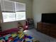 Well-lit bedroom with a large window, dresser, and space for activities at 1851 S Dunkirk St # 201, Aurora, CO 80017