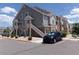 Exterior view of the apartment building, showcasing the architecture and reserved parking with lush landscape at 1851 S Dunkirk St # 201, Aurora, CO 80017