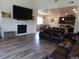 Open-concept living room featuring a fireplace, large TV, wood floors, and an attached modern kitchen at 1851 S Dunkirk St # 201, Aurora, CO 80017