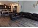 Inviting living room with open kitchen, modern decor, wood floors, and comfortable leather seating at 1851 S Dunkirk St # 201, Aurora, CO 80017