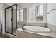 Modern bathroom featuring a large soaking tub and a glass-enclosed shower at 25283 E Warren Pl, Aurora, CO 80018