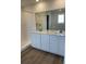 Bathroom featuring walk-in shower, white vanity with double sinks and wood-look flooring at 3909 N Shawnee St, Aurora, CO 80019