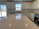 Bright kitchen featuring white cabinets, expansive quartz countertops, and stainless steel appliances at 3909 N Shawnee St, Aurora, CO 80019