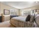 Serene bedroom featuring bright windows, a stylish bed with decorative pillows, and a sleek dresser against a soft beige wall at 2770 S Elmira St # 42, Denver, CO 80231