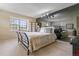 Inviting bedroom with a mirrored wall, bright window, stylish metal bed frame and decorative pillows with a lamp at 2770 S Elmira St # 42, Denver, CO 80231