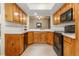 Functional kitchen features light wooden cabinets, black appliances, and ample counter space for easy meal preparation at 2770 S Elmira St # 42, Denver, CO 80231