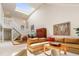 Light filled living room showcasing vaulted ceiling, skylight, and an open staircase at 2770 S Elmira St # 42, Denver, CO 80231