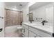 Bright bathroom features a double sink vanity, bathtub with shower, and neutral tiling at 9359 Russell Cir, Arvada, CO 80007