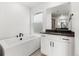 Modern bathroom featuring a soaking tub, vanity with a dark countertop and neutral tile flooring at 9359 Russell Cir, Arvada, CO 80007
