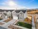 A modern two-story gray home boasts a well-manicured lawn and charming curb appeal on a sunny day at 9359 Russell Cir, Arvada, CO 80007