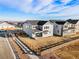 A gray two-story home features a modern exterior, sidewalk, and a rustic wood fence, creating a welcoming curb appeal at 9359 Russell Cir, Arvada, CO 80007