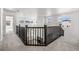 Open foyer with dark wooden railing and a fireplace below, illuminated by natural light at 9359 Russell Cir, Arvada, CO 80007