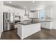 Bright kitchen features stainless steel appliances, an island with bar seating, and dark countertops at 9359 Russell Cir, Arvada, CO 80007