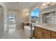 Luxurious bathroom with dual vanities, soaking tub, and a large window offering scenic mountain views at 4121 Mesa Top Dr, Monument, CO 80132