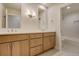 Bathroom with double sink, wood cabinets, white countertops, and tiled floors and shower at 4121 Mesa Top Dr, Monument, CO 80132