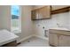 Functional laundry room with ample storage, a utility sink, and a window providing natural light at 4121 Mesa Top Dr, Monument, CO 80132