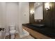 Modern powder room with floating vanity, black granite countertop and wood accents at 4121 Mesa Top Dr, Monument, CO 80132