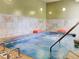 Indoor hot tub surrounded by decorative tile and handrails at 13961 E Marina Dr # 414, Aurora, CO 80014