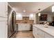 Bright kitchen with stainless appliances, white cabinets, island with white countertop, and tile backsplash at 13961 E Marina Dr # 414, Aurora, CO 80014