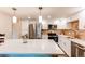 Beautiful bright kitchen with stainless appliances, island with white countertop, and tile backsplash at 13961 E Marina Dr # 414, Aurora, CO 80014