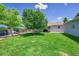 Backyard features a lush lawn, deck with seating, and shade trees at 3313 S Dexter St, Denver, CO 80222