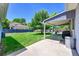 A backyard includes a covered patio, seating, barbecue, and lush green lawn at 3313 S Dexter St, Denver, CO 80222