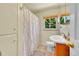 Bathroom with a light wood vanity, a shower with curtain, and natural lighting at 3313 S Dexter St, Denver, CO 80222