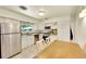 Bright kitchen with stainless steel appliances, white cabinets, and dining table at 3313 S Dexter St, Denver, CO 80222