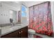 Bathroom featuring a granite countertop vanity, floral shower curtain, and a window offering natural lighting at 10909 Memphis Ct, Commerce City, CO 80022