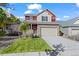 Charming two-story home with stone accents, a well-manicured lawn and an attached two car garage at 10909 Memphis Ct, Commerce City, CO 80022