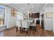 Eat-in kitchen with wood floors, stainless steel appliances, white cabinets and a table with four chairs at 10909 Memphis Ct, Commerce City, CO 80022