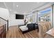Bright living room with a black sectional sofa, wood floors, large windows, and recessed lighting at 10909 Memphis Ct, Commerce City, CO 80022