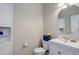 Cozy powder room with blue accents and vanity with sink and round mirror at 3733 S Perth Cir # 101, Aurora, CO 80013