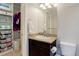 Bathroom vanity with drawers and granite countertop, next to a closet with shelving and wire basket storage at 3733 S Perth Cir # 101, Aurora, CO 80013