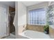 Modern bathroom with soaking tub, glass block window, and separate shower with tile surround at 3733 S Perth Cir # 101, Aurora, CO 80013