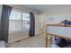 Bright bedroom with bunkbeds, louvered windows and a full-size window with curtains at 3733 S Perth Cir # 101, Aurora, CO 80013