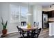 Bright dining area with a round glass-top table, modern lighting, and large windows with shutter-style blinds at 3733 S Perth Cir # 101, Aurora, CO 80013