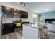 Modern kitchen with stainless steel appliances, an island with bar seating, and a view into the adjacent living area at 3733 S Perth Cir # 101, Aurora, CO 80013