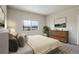 Cozy bedroom features a large bed, wood dresser, neutral walls, and a window view at 12444 Madison Way, Thornton, CO 80241