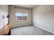 Bedroom features a large window, soft carpet, neutral walls, and a side table at 12444 Madison Way, Thornton, CO 80241