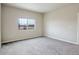 This bright bedroom features soft carpeting and a window with a view of the outdoors at 12444 Madison Way, Thornton, CO 80241