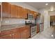 Modern kitchen with wood cabinets and granite countertops at 12444 Madison Way, Thornton, CO 80241